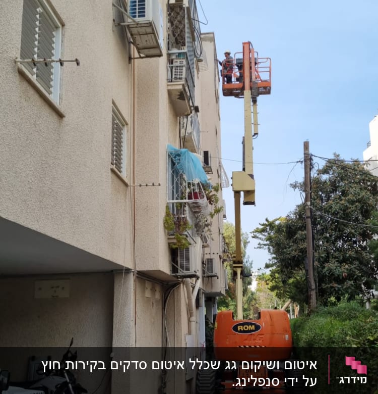 מנוף הרמה ליד בניין מגורים עם פועלים